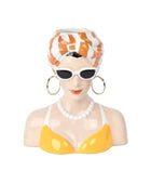 Decorative bust of a woman wearing sunglasses, a yellow swimsuit, and a striped headscarf on a white background.