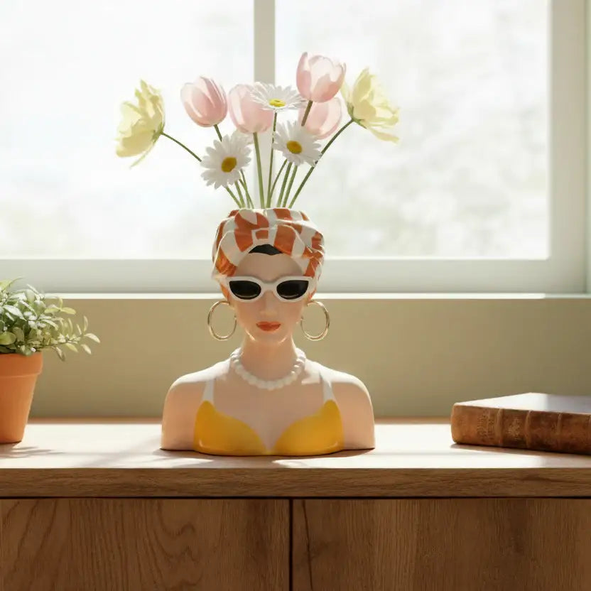 Vase shaped like a woman's head with sunglasses and flowers on a wooden surface