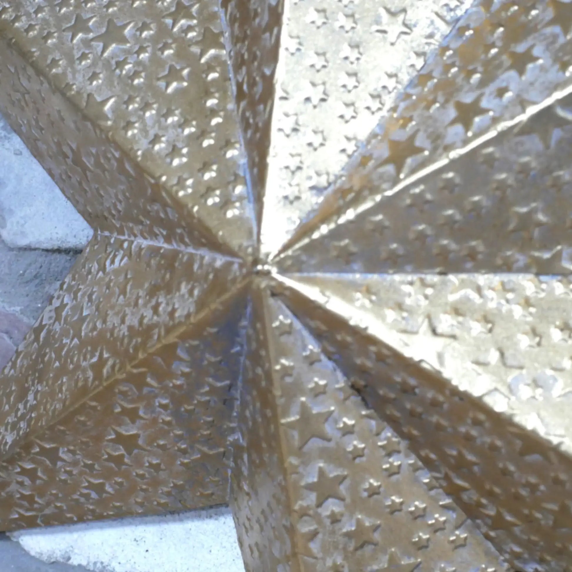 Decorative metal star with intricate cut-out patterns on a textured surface
