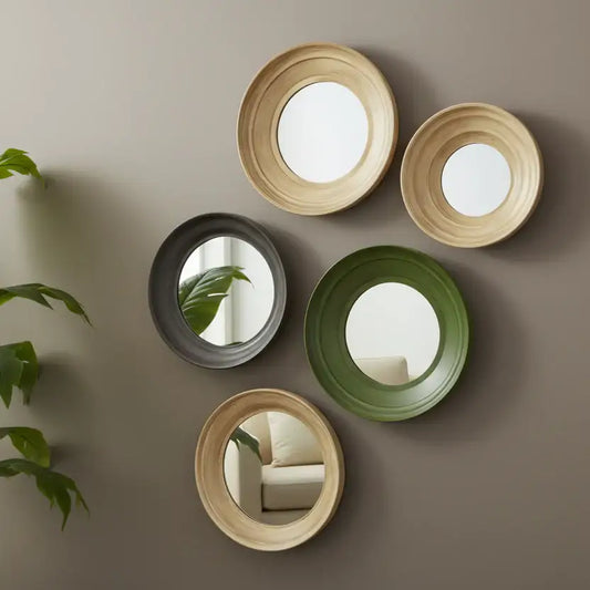 Five round mirrors in different colors on a beige wall with a plant to the left.