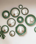 Wall with decorative mirrors in green frames and a plant on the left.