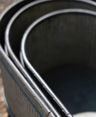 Close-up of a set of metal buckets on a gravel surface
