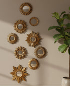 Decorative gold mirrors on a wall with a potted plant in the corner