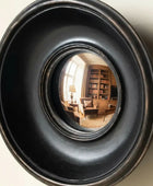 Round black metallic object with reflective interior