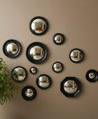 Set of round metallic mirrors in various sizes on a white background