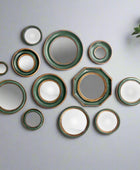 Set of ceramic plates with green and gold trim on a white background