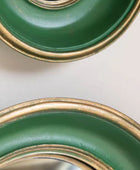 Two green plates with gold rims on a light background