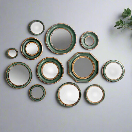 Set of ceramic plates with green and gold trim on a white background