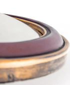 Close-up of a metallic ring with a white object inside on a light background