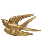 A metallic gold swallow bird figurine or ornament, shown in profile with wings spread, on a plain white background.