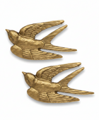 Two matching gold-toned bird-shaped accessories with wings and tails, shown on a plain white background.