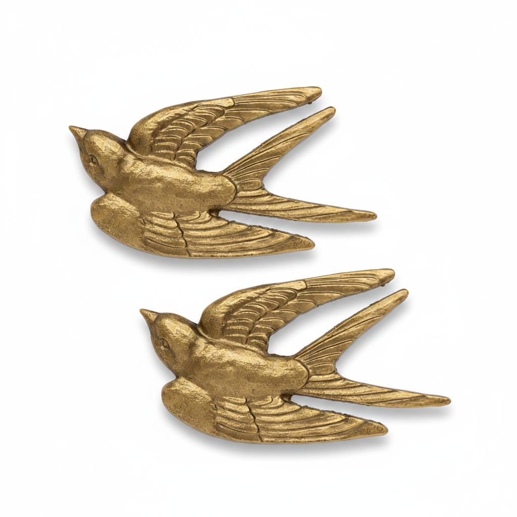 Two matching gold-toned bird-shaped accessories with wings and tails, shown on a plain white background.
