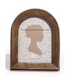 Antique gold ribbed arch photo frame with silhouette design on a white background