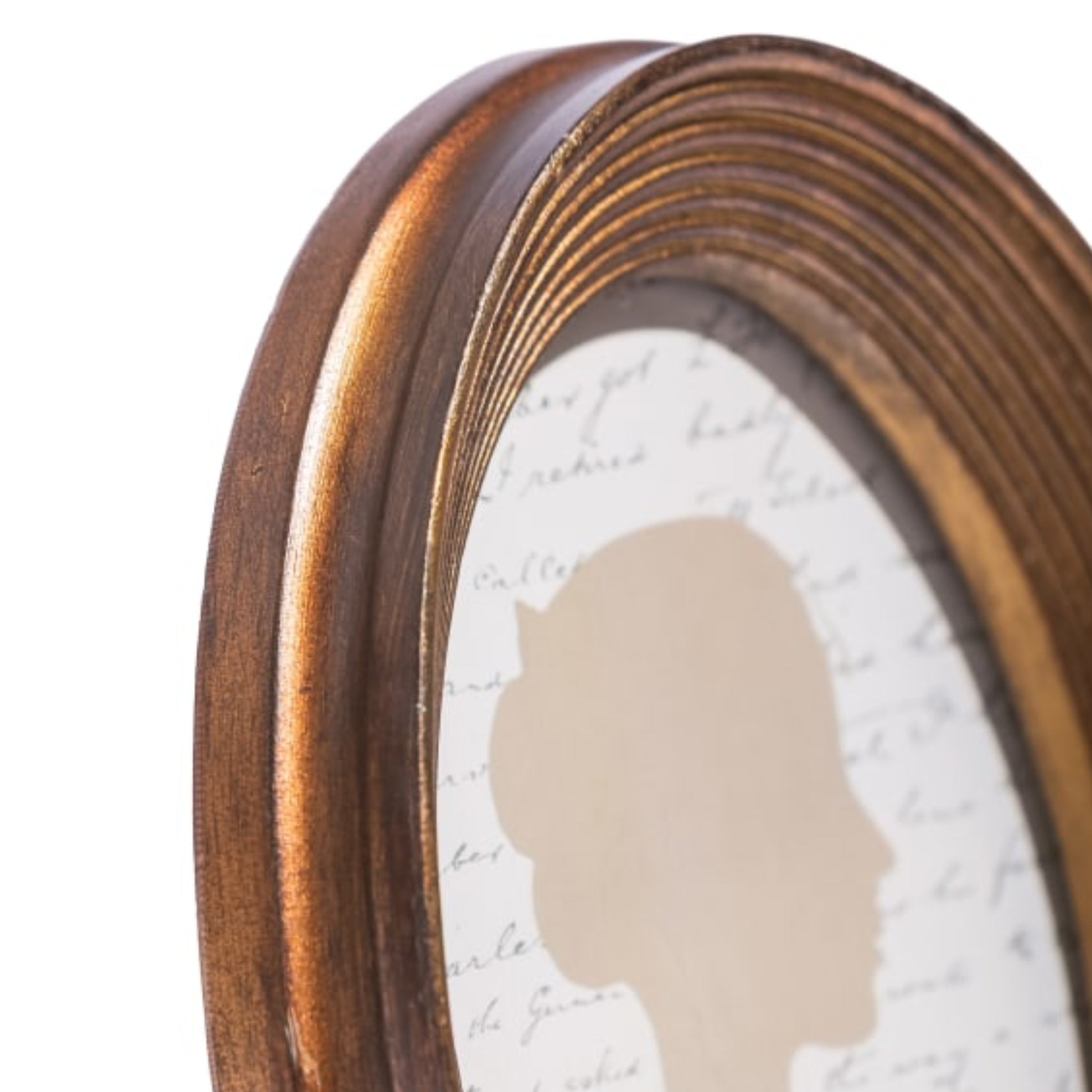 Close-up of a bronze-colored mirror frame with a textured white background