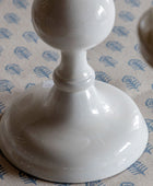 White ceramic candlestick on a patterned surface