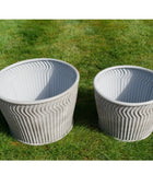 Two textured planters on a grassy background