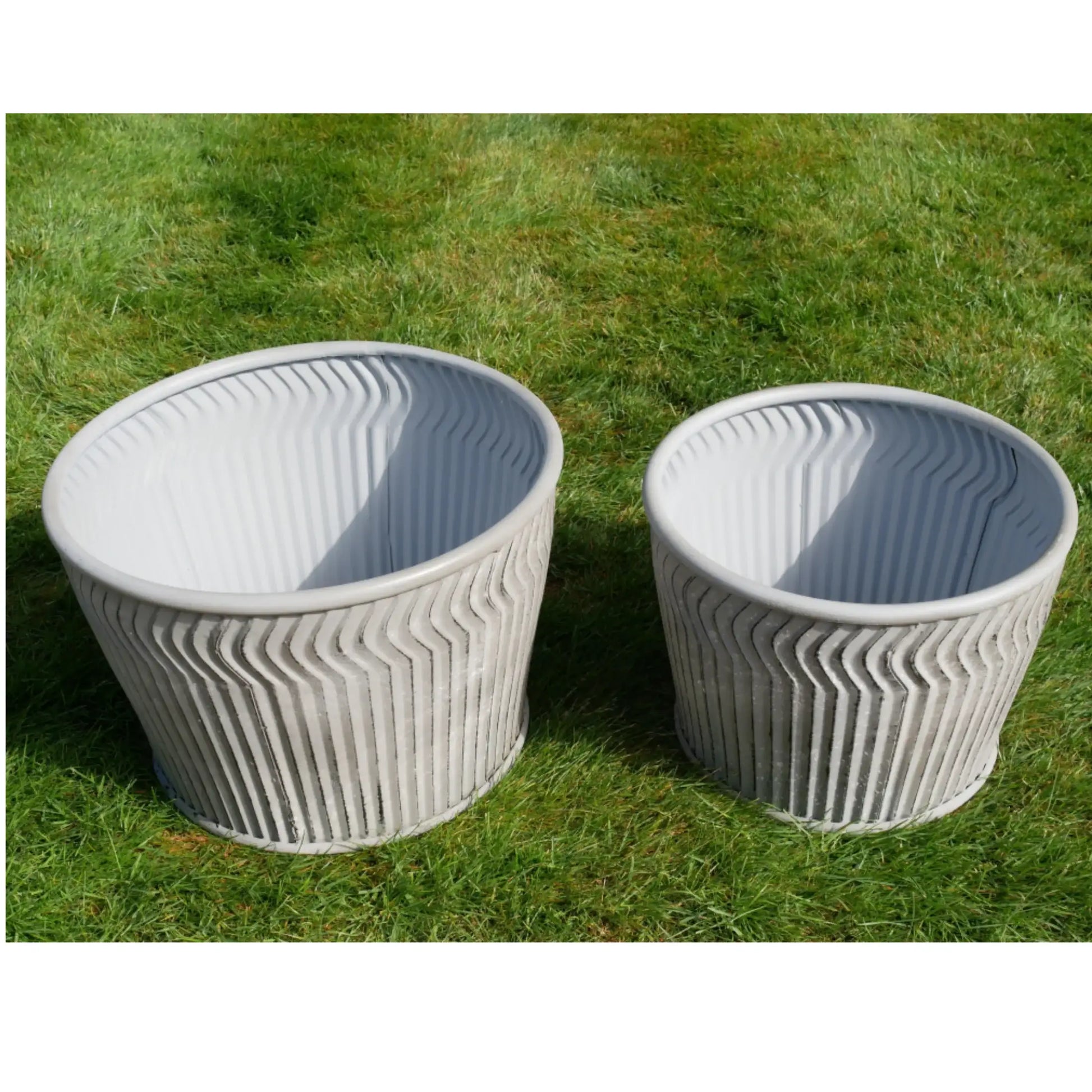 Two textured planters on a grassy background