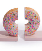 A pair of novelty donut-shaped bookends with colorful sprinkles on a white background.