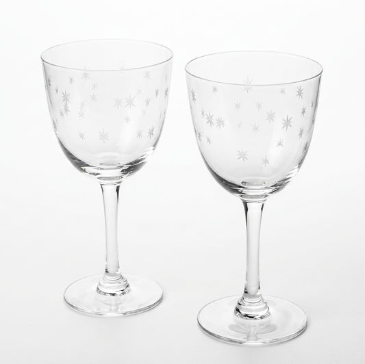 Two clear wine glasses with white star etchings, displayed in front of their brown cardboard packaging box on a white background.