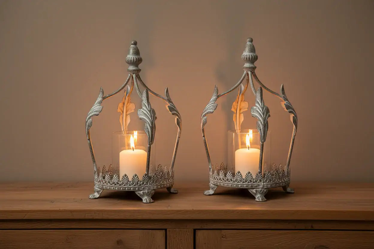 Two ornate candle lanterns on a wooden surface with a neutral background