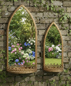 Two ornate mirrors on a stone wall reflecting a garden with flowers.