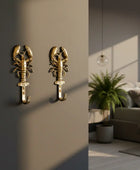 Gold lobster-shaped wall hook on a dark background