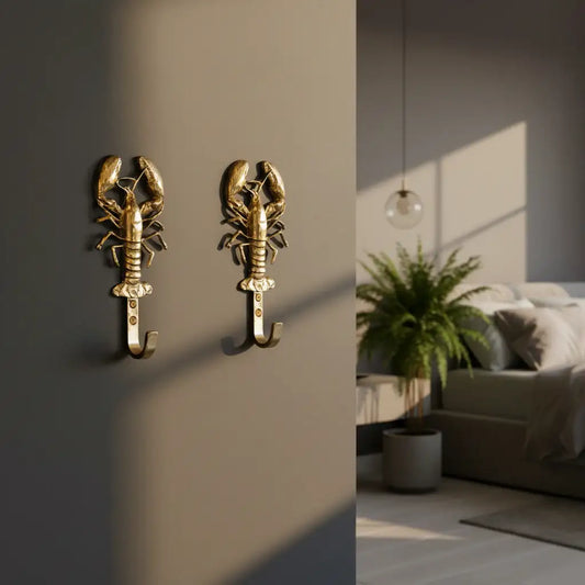 Gold lobster-shaped wall hook on a dark background