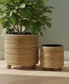 Two woven planters with plants on a wooden surface