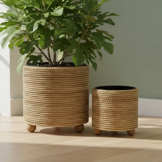 Two woven planters with plants on a wooden surface
