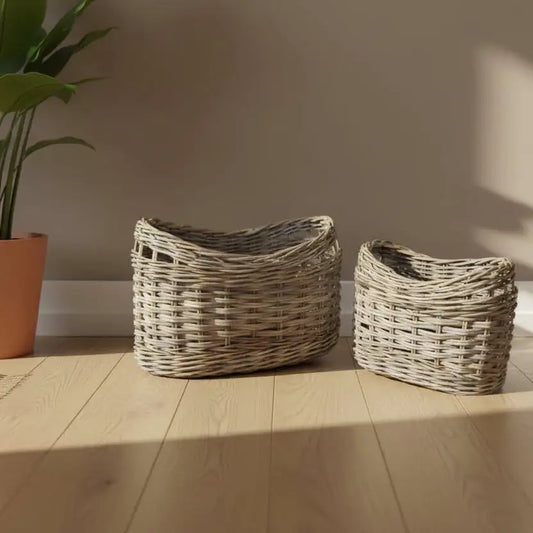 Two wicker baskets on a wooden floor with a plant in the background