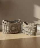Two wicker baskets on a wooden floor with a neutral wall background