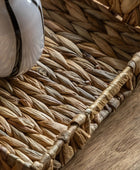 Close-up of a woven basket with a white object inside on a wooden surface