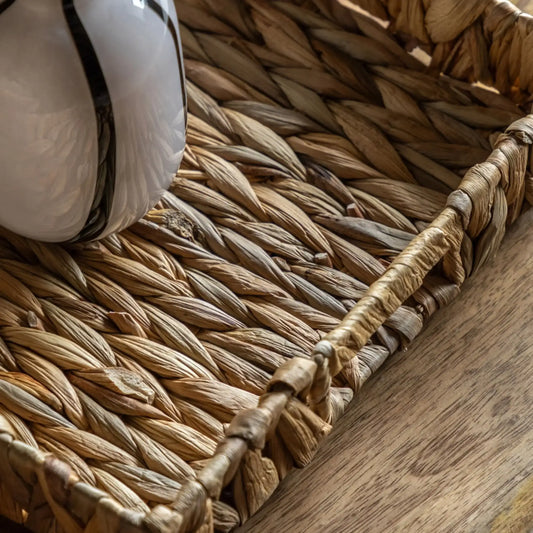 Close-up of a woven basket with a white object inside on a wooden surface