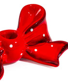 A glossy red bow-shaped ceramic dish with white polka dots, shown on a clean white background.