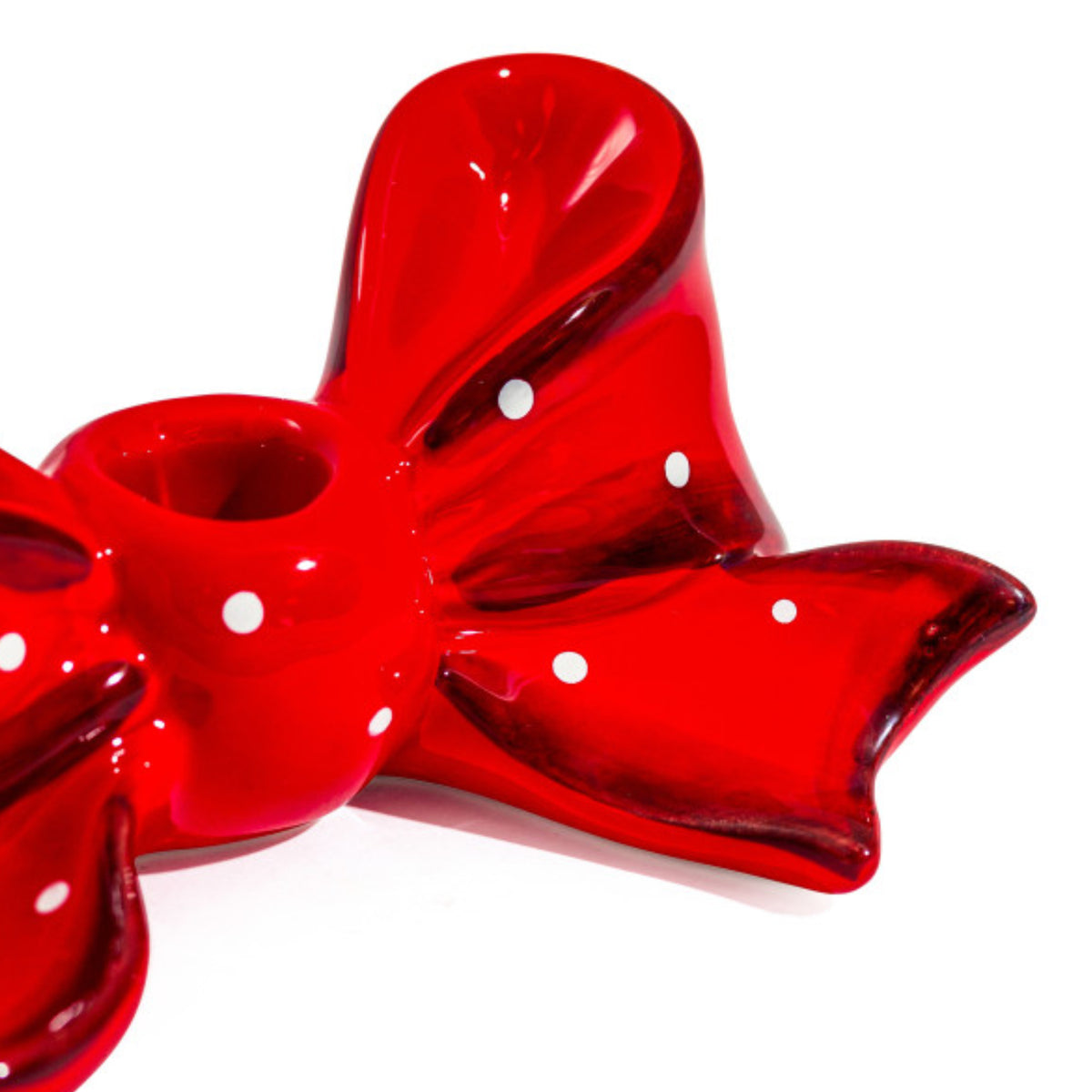 A glossy red bow-shaped ceramic dish with white polka dots, shown on a clean white background.