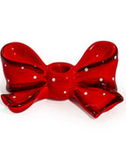 A glossy red bow-shaped candle holder with white polka dots, set against a plain white background.