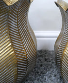 Two decorative vases with gold leaf pattern on a textured surface