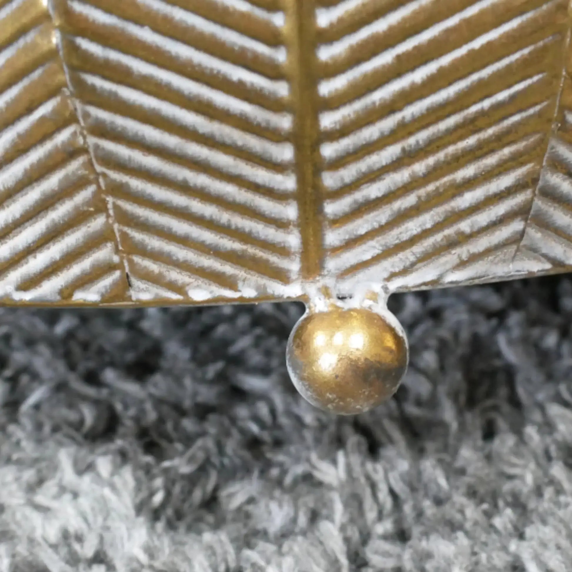 Gold leaf with a central droplet on a textured gray background