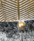 Gold leaf with a central droplet on a textured gray background