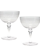Two clear glass coupe glasses with etched geometric patterns on the bowls and stems, shown on a plain white background.
