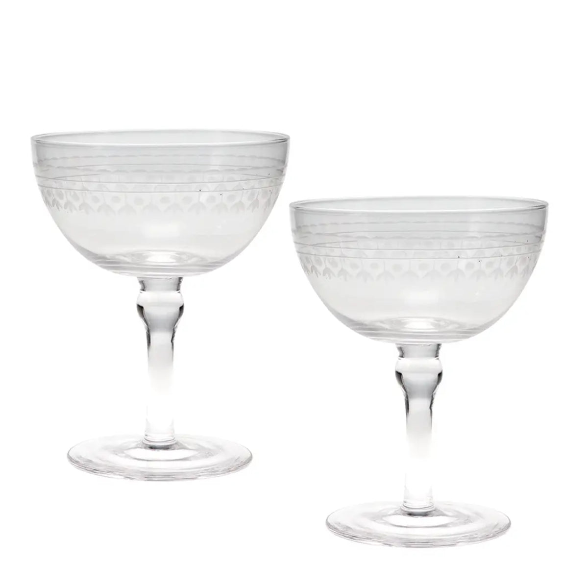 Two clear glass coupe glasses with etched geometric patterns on the bowls and stems, shown on a plain white background.