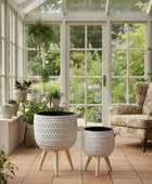 Two decorative planters with woven design and wooden legs on a white background