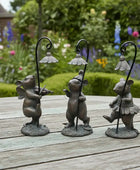 Three decorative mouse figures with lampshades on a wooden surface with a garden background.
