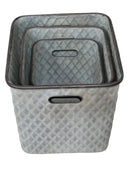 Set of three textured storage baskets on a wooden surface