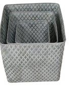 Set of three gray woven baskets on a wooden surface with a neutral background