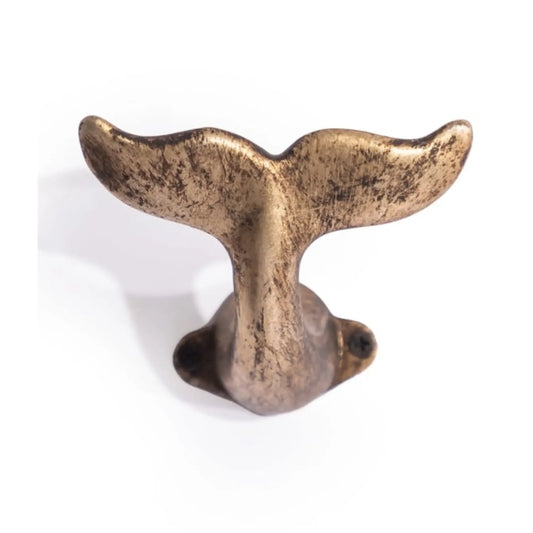 Bronze whale tail decorative item on a white background