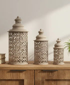 Decorative lanterns on a wooden surface with a plant and books in the background