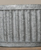 Corrugated metal planter on a wooden surface with a neutral background