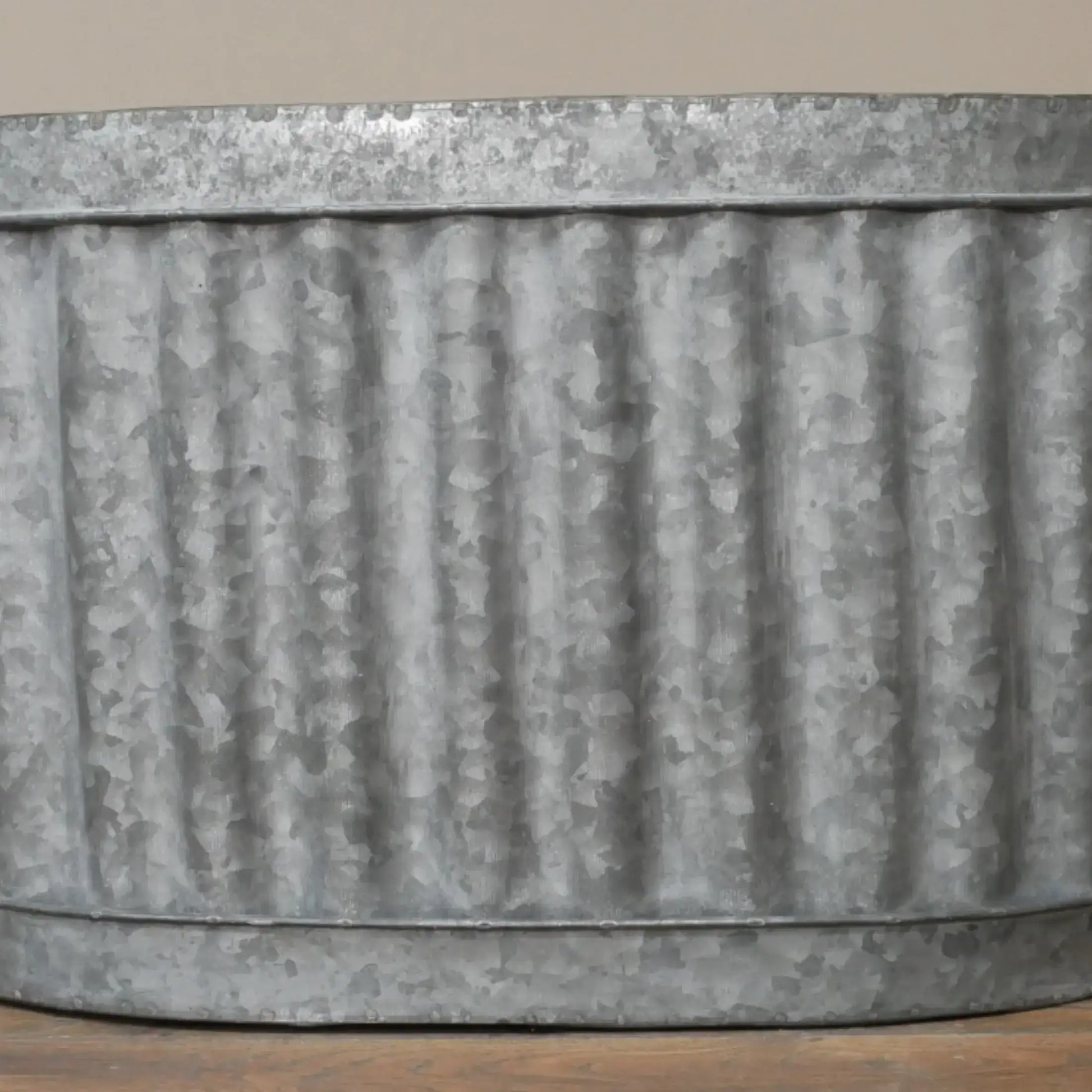 Corrugated metal planter on a wooden surface with a neutral background