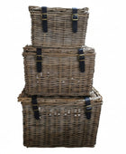 Stack of three wicker baskets with black straps on a white background